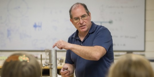 uvm physics instructor demonstrates lab equipment to a class