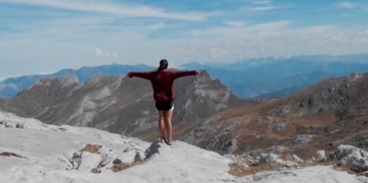 student on top of mountain