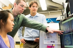 Students review a scan with their professor