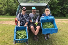 farm students sitting in pick up truck with bins of produce
