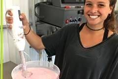 student using hand blender in vat