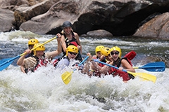 People in a raft in the rapids of a river