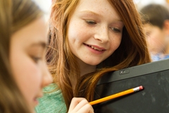 Middle school-aged children working at computers