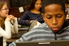 Middle school-aged children working at computers
