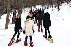 Students snowshow up a trail
