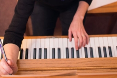 piano keyboard with hands playing