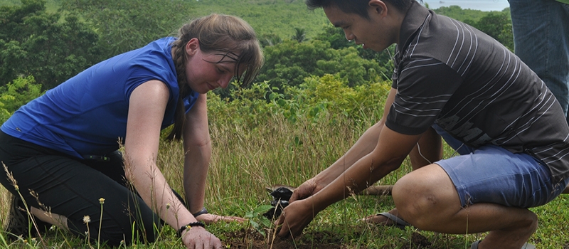 two students working in a field while on peace corps mission