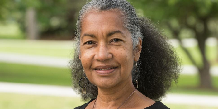 Bev Belisle smiling in front of UVM campus green