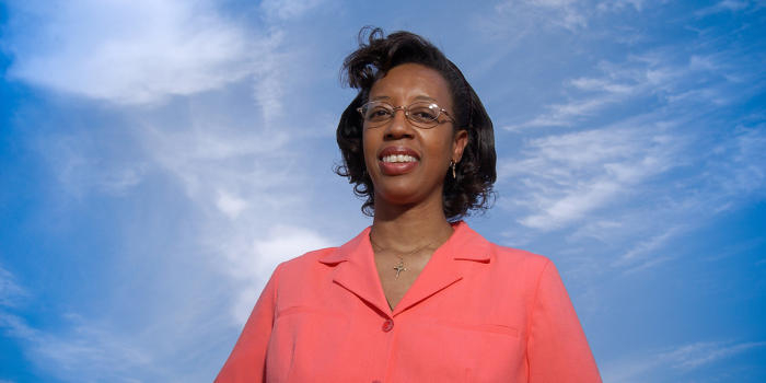 Lesley-Ann in bright coral colored blouse against blue skies