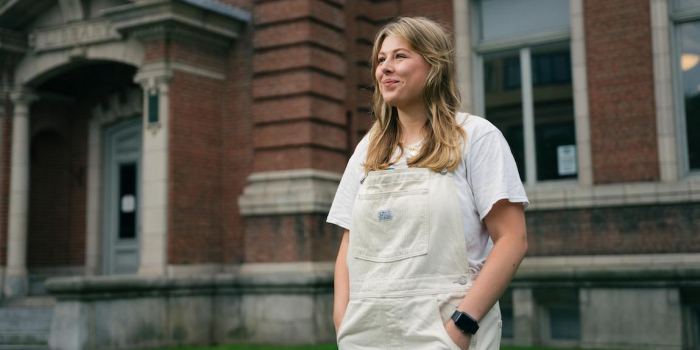 Alaura Rich standing in front of brick building looking hopeful