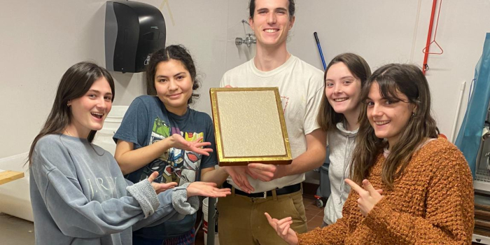 Students holding paper product 