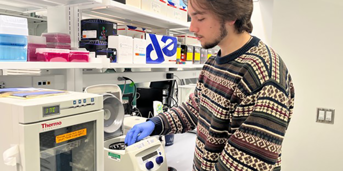 Lucas Leon places samples into a centrifuge.