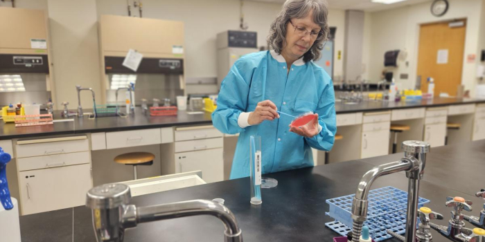 Lynn Willette, Research Assistant, prepares cultures in the lab.