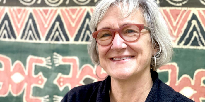profile photo of Polly Ericksen standing in front of a patterned backdrop.
