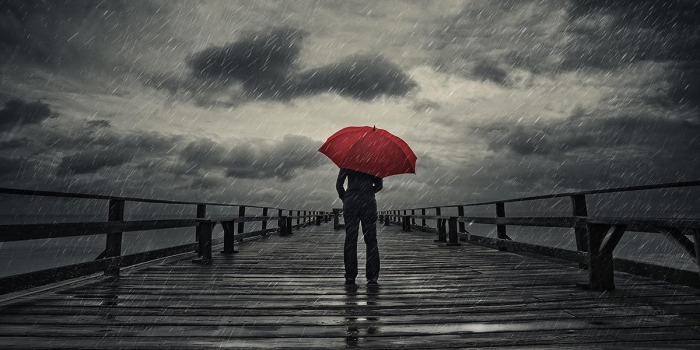 person holding umbrella in storm