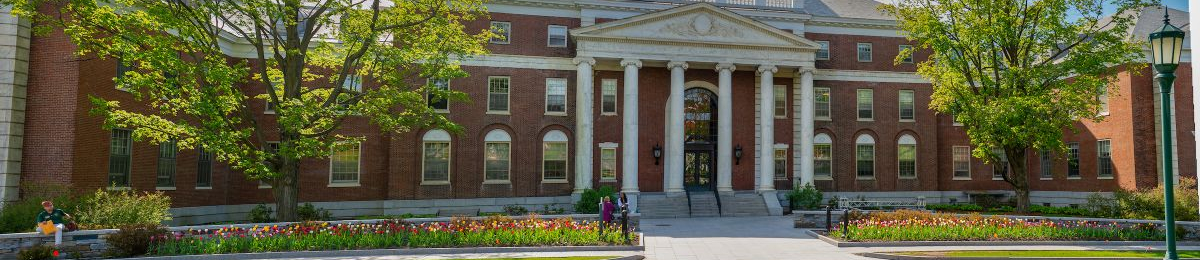 Waterman building with students enjoying the early spring flowers and trees