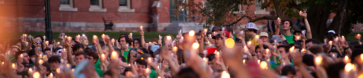 Students holding candles on main green