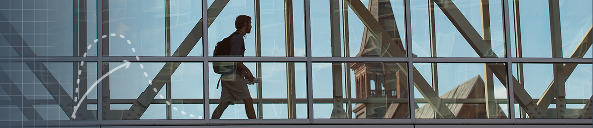 Student walking across a bridge 