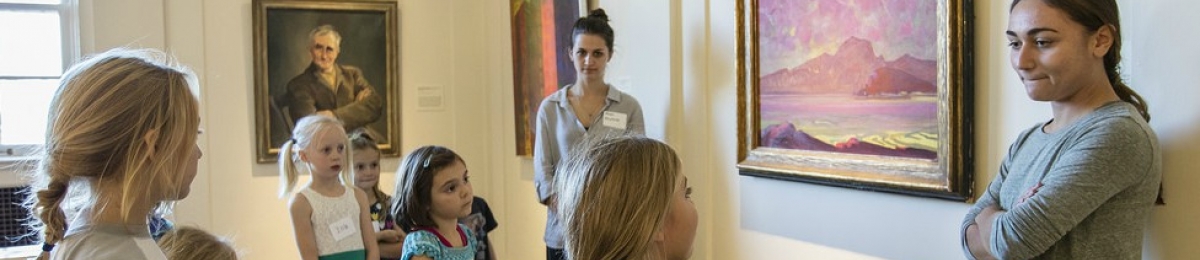 student employee working with a group of young students at the fleming museum