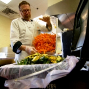 Kitchen worker dumping food scraps 