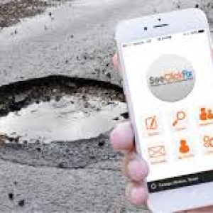 a pothole and someone taking a photo of it