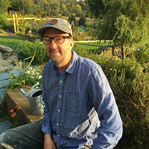 Mark Usher surrounded by plants and greenery of his farm