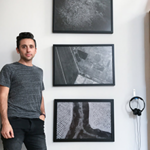 Lorenzo Triburgo standing by 3 pieces of his work