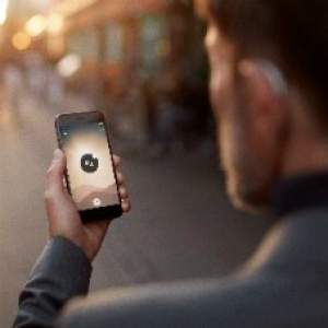 user with bluetooth hearing aid on noisy street