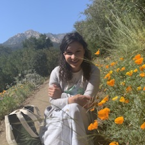 Ashley Lantigua with orange wildflowers and mountains