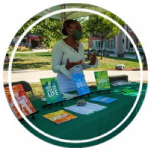 a student standing at a table outside