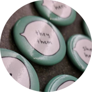 blue pins with word bubbles that have different pronouns listed in them.