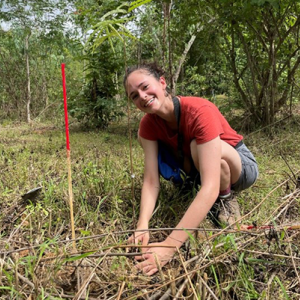 Phoebe smiling for the camera surrounded by elephant habitat