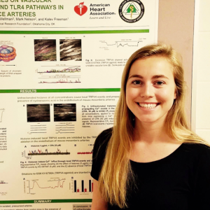 Laurel Haines presenting a reserach poster student in front of research poster