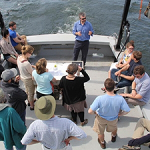 Students listen to an instructor lecture aboard a boat