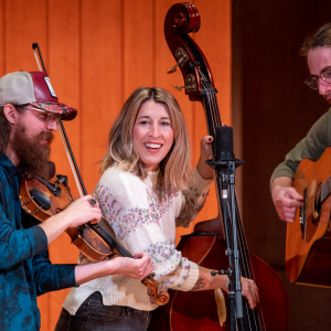 A trio of musical performers: guitar, violin and cello.