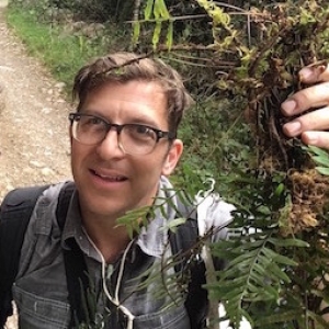 Michael in the field, holding up a fern