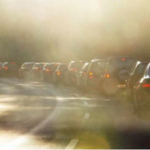 a line of cars stopped on a highway in a haze of emissions
