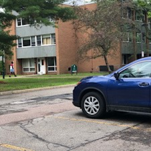 student walking into building and parking lot