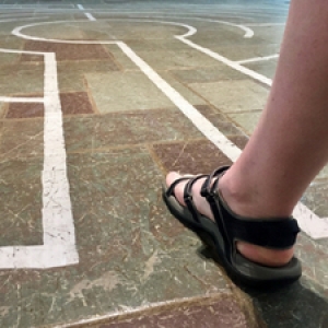 A person's foot walking into the labyrinth pattern A person's foot walking into the labyrinth pattern
