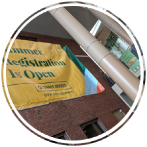 a large banner hangs between two columns in the davis center atrium