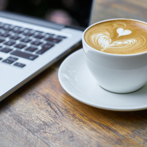 a latte next to a laptop