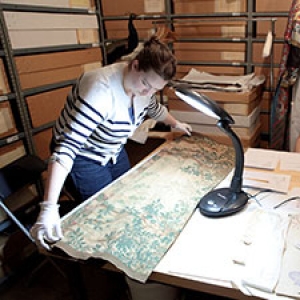A UVM student examines textiles in the Museum's storage area