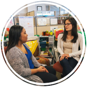 two students talking to each other in a cubicle in student life