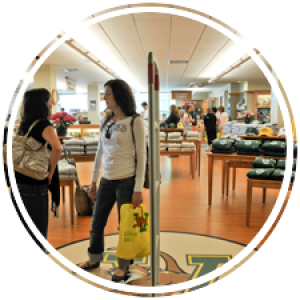 two students talk to each other in the entry way to the uvm bookstore