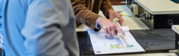staff person reviewing a floor plan diagram