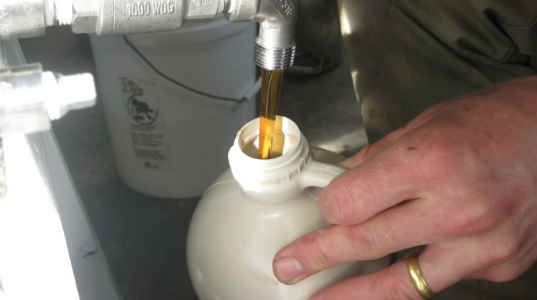 syrup flows out of a tap into a jug