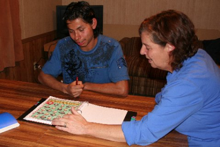 Volunteer Sally assisting student Antonio with his studies.