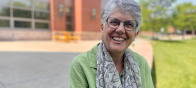 Sharon is outside the Davis Center on a sunny day