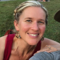 Kelly Savitri: a pale-skinned woman in her late thirties, with blond hair pulled back in a braid across the crown of her head. She smiles only slightly at the camera.