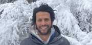 Jorge Garcia smiling broadly with snow covered evergreens in the background